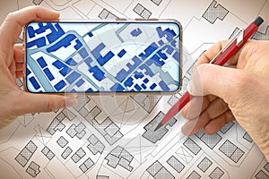 Hand drawing an imaginary cadastral map of territory with buildings and land parcel - concept with smarphone