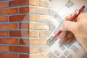 Hand drawing an imaginary cadastral map of territory with buildings, roads and brick wall on foreground