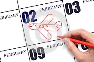 A hand drawing outline of airplane on calendar date 2 February. The date of flight on plane.