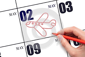 A hand drawing outline of airplane on calendar date 2 May. The date of flight on plane.