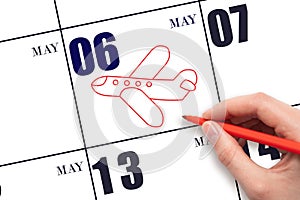 A hand drawing outline of airplane on calendar date 6 May. The date of flight on plane.