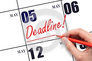 Hand drawing red line and writing the text Deadline on calendar date May 5. Deadline word written on calendar