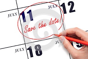 Hand drawing red line and writing the text Save the date on calendar date July 11.