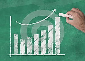 Hand drawing rising curve chart on blackboard illustrating business success or rising stock prices