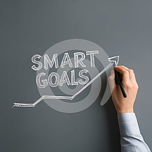 Hand drawing SMART GOALS line graph on gray background, symbolizing progress and productivity