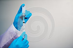 Hand drawing vaccine bottle into syringe injection medicine