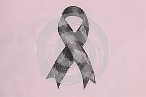 Hand-drawn black breast cancer ribbon on a pink background, symbolizing mourning and remembrance