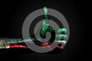 A hand with a drawn Chechnya flag shows a finger up sign, a symbol of success, readiness, a task done on a dark background