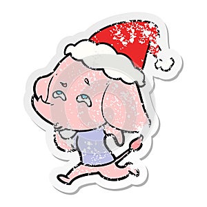 hand drawn distressed sticker cartoon of a elephant remembering wearing santa hat