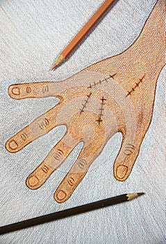 Hand drawn right hand with surgical wound suture by wooden color pencils on white paper background on table,Halloween concept.