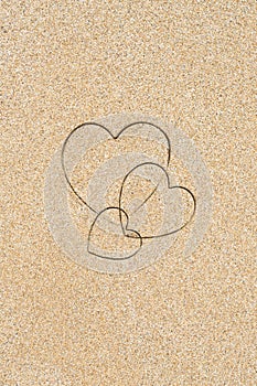 Hand-drawn shape of three heart on sand tropical beach. valentines day. Holiday, the vacation of family, friends concept. Creative