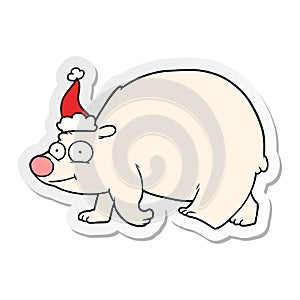 hand drawn sticker cartoon of a walking polar bear wearing santa hat
