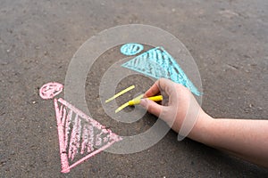 The hand draws a chalk equal sign between the male and female symbol on the asphalt