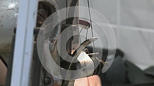 Hand of a dressmaker supporting a cloth while sewing on a machine