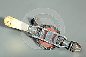 Hand drill with yellow handle on a gray