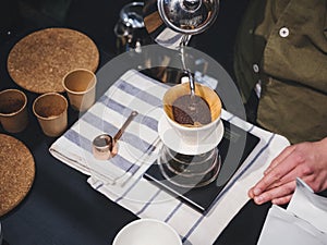 Hand Drip Coffee Barista pouring water on coffee ground with filter