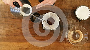 Hand drip coffee , barista pouring water on coffee ground with filter