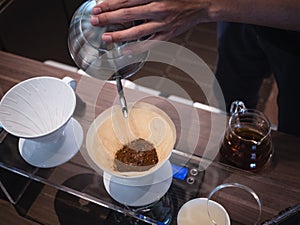 Hand drip coffee Barista pouring water on coffee ground with filter