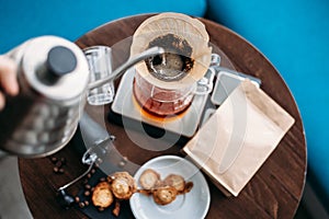 Hand drip coffee, barista pouring water on coffee ground with filter