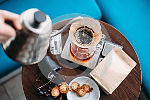 Hand drip coffee, barista pouring water on coffee ground with filter