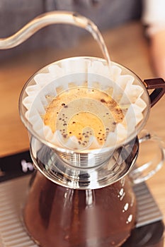 Hand drip coffee, Barista pouring water on coffee ground with filter photo