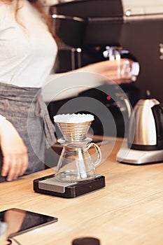 Hand drip coffee, Barista pouring water on coffee ground with filter photo