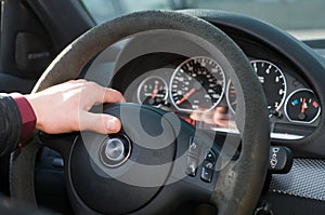 Hand of the driver on a steering wheel.