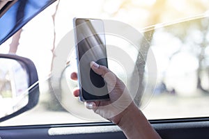 The hand of driver is using a mobile phone to help navigate or GPS.