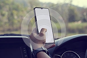 Hand of driver is using a mobile phone to help navigate or GPS while parking on the side of the road.