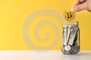 Hand drop gold Bitcoin the jar full of coin and bank notes meaning of saving investment with cryptocurrency digital money fintech
