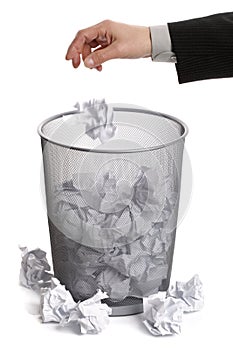 Hand dropping paper into wastepaper bin