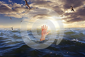 Hand of drowning man in sea asking for help