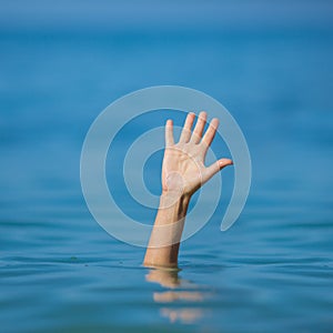 Hand of drowning man in sea or ocean asking for help