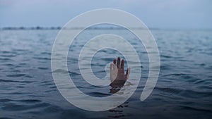 Hand of a drowning man sinks into the water, concept of a person mired in debt and unable to help himself
