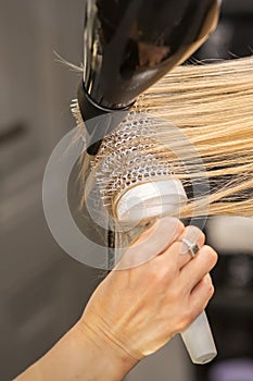 Hand drying hair of woman