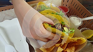 Hand eating corn tortilla carnitas taco with avocado Mexican poppular food