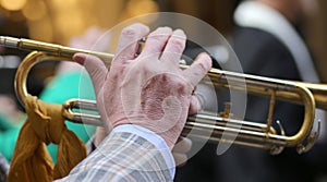 hand of elderly man playing the trumpet in the music band