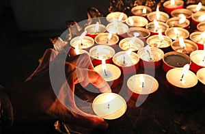 hand of an elderly woman lighting a candle during the religious