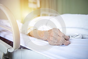 Hand of elderly woman patient sleeping on bed in room hospital blur background