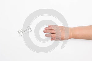 The hand of an elderly woman reaches for pills on a white background, the concept of placebo pills, health, close-up, copy space