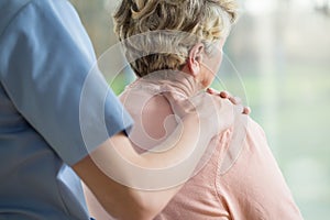 Hand on elderly woman's shoulder