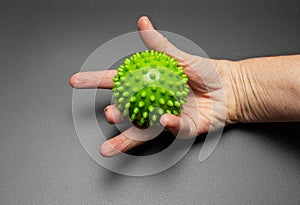 The hand of an elderly woman is squeezing a relief ball. Exercises for hands and fingers. Rehabilitation