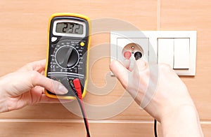Hand electrician checking voltage