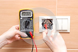Hand electrician checking voltage