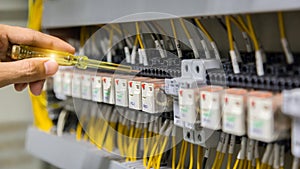 Electricians hands testing current  electric in control panel