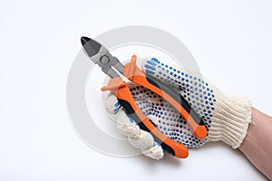 Hand of an electrician in protective gloves holding wire cutters against white background