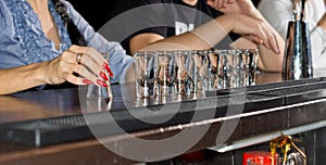 Hand of an elegant woman holding a shot glass