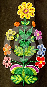 Hand embroidery in the form of colorful flowers on a woman`s skirt. Traditional crafts of Bulgaria