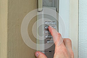 Hand entering code on keypad - garage door opener - home security