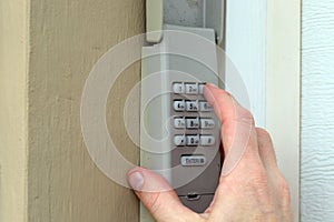 Hand entering code on keypad - garage door opener - home security